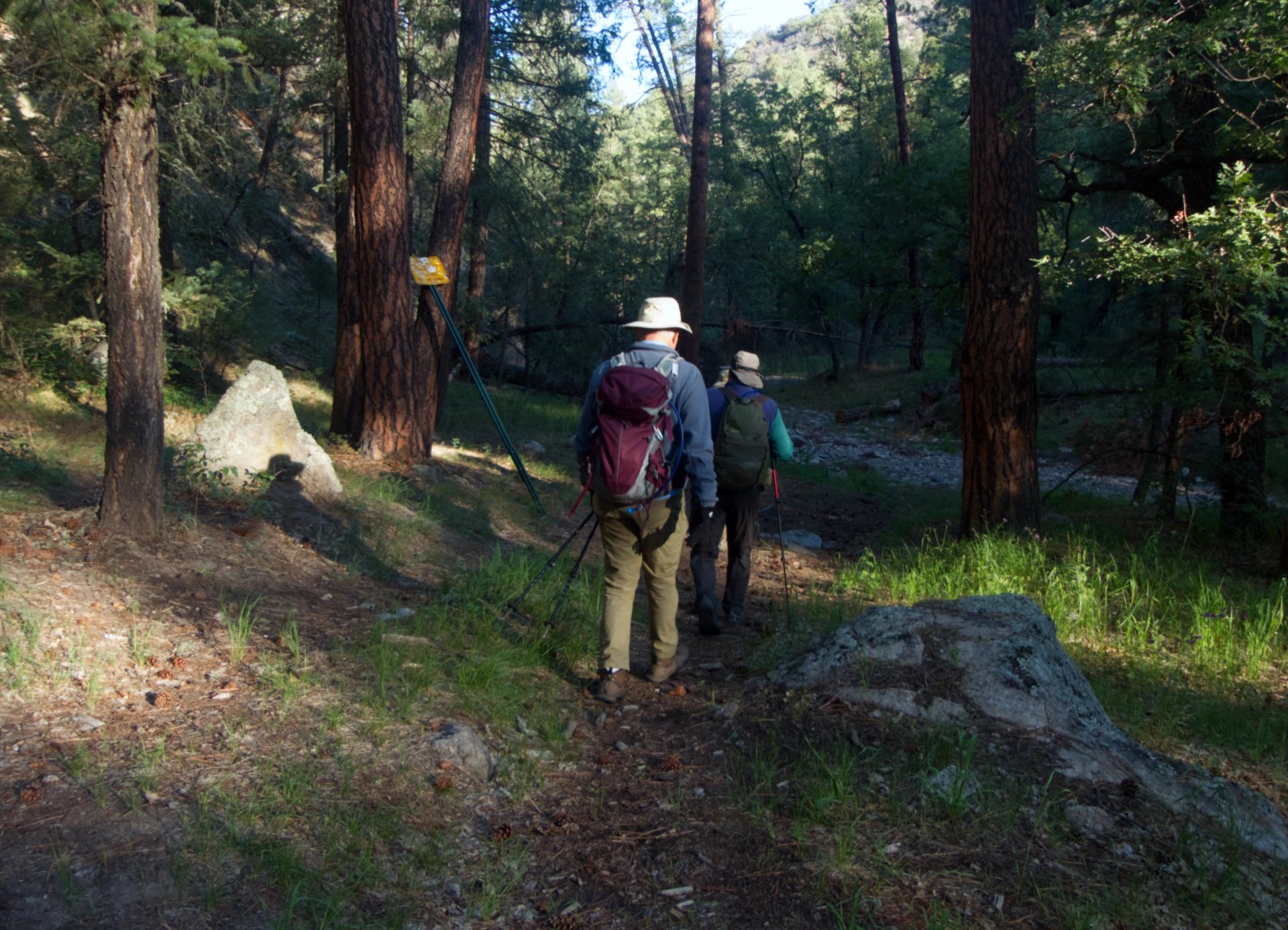 two hikers approaching a dry creek