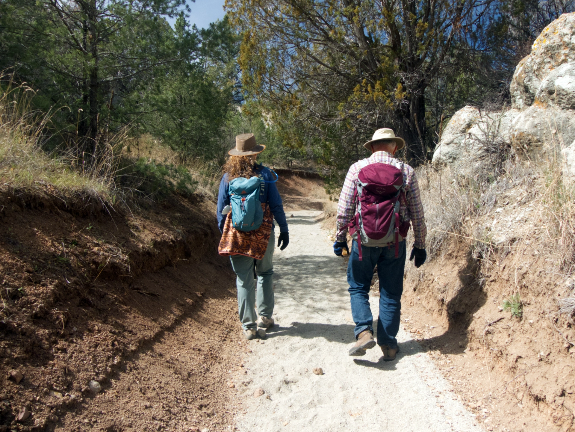 Debra and Dennis walking back to camp in a narrow wash