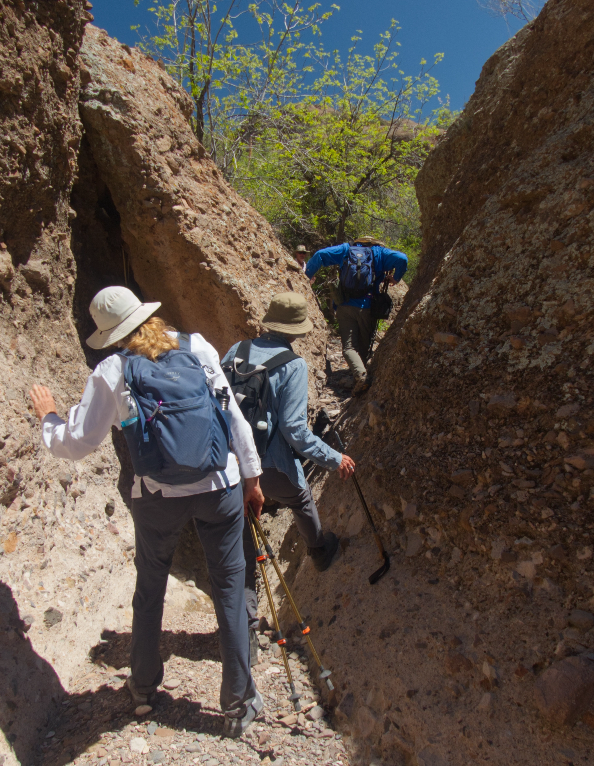 hikers crawling over a large choke stone