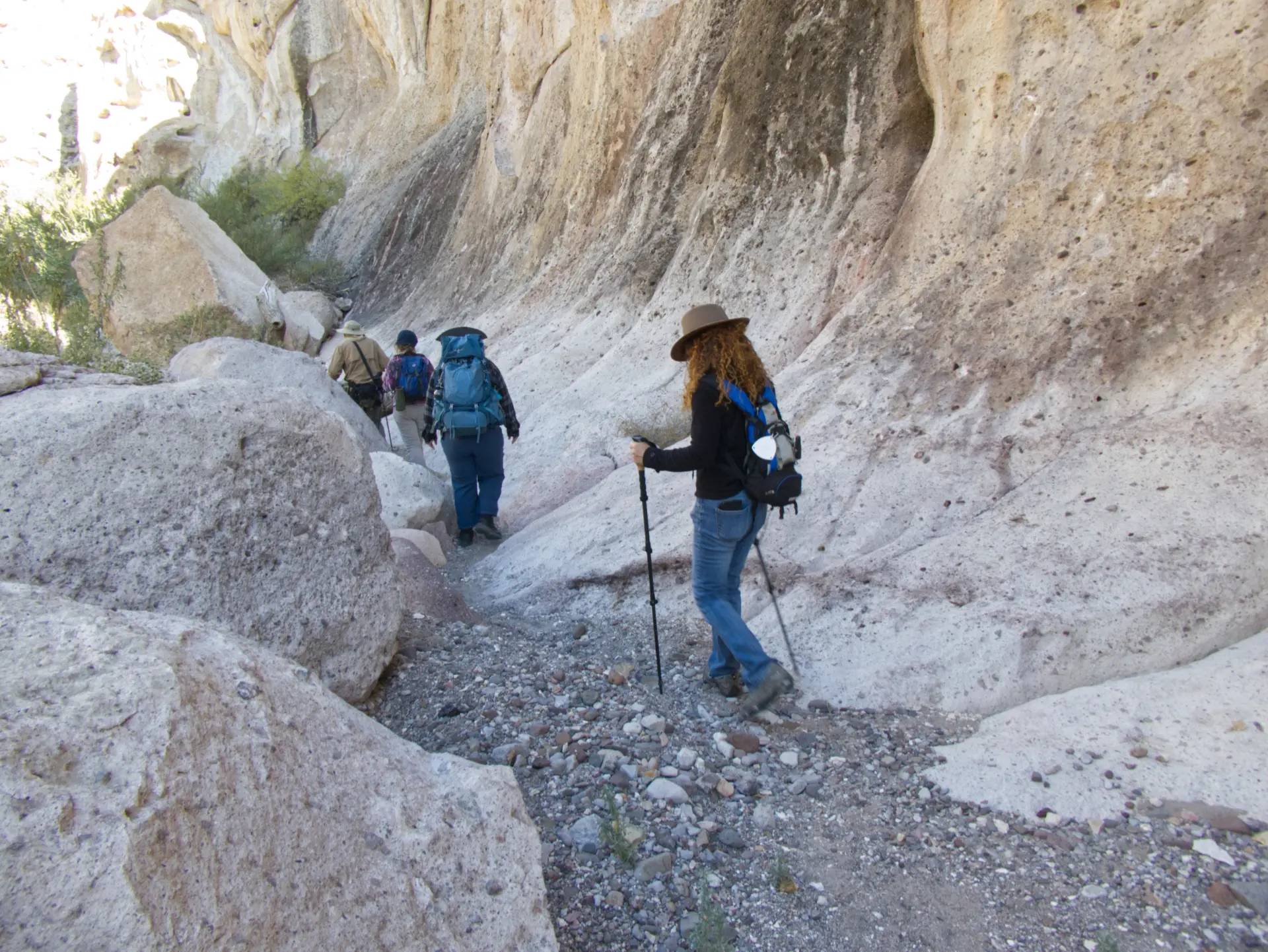 hikers near steep canyon wall