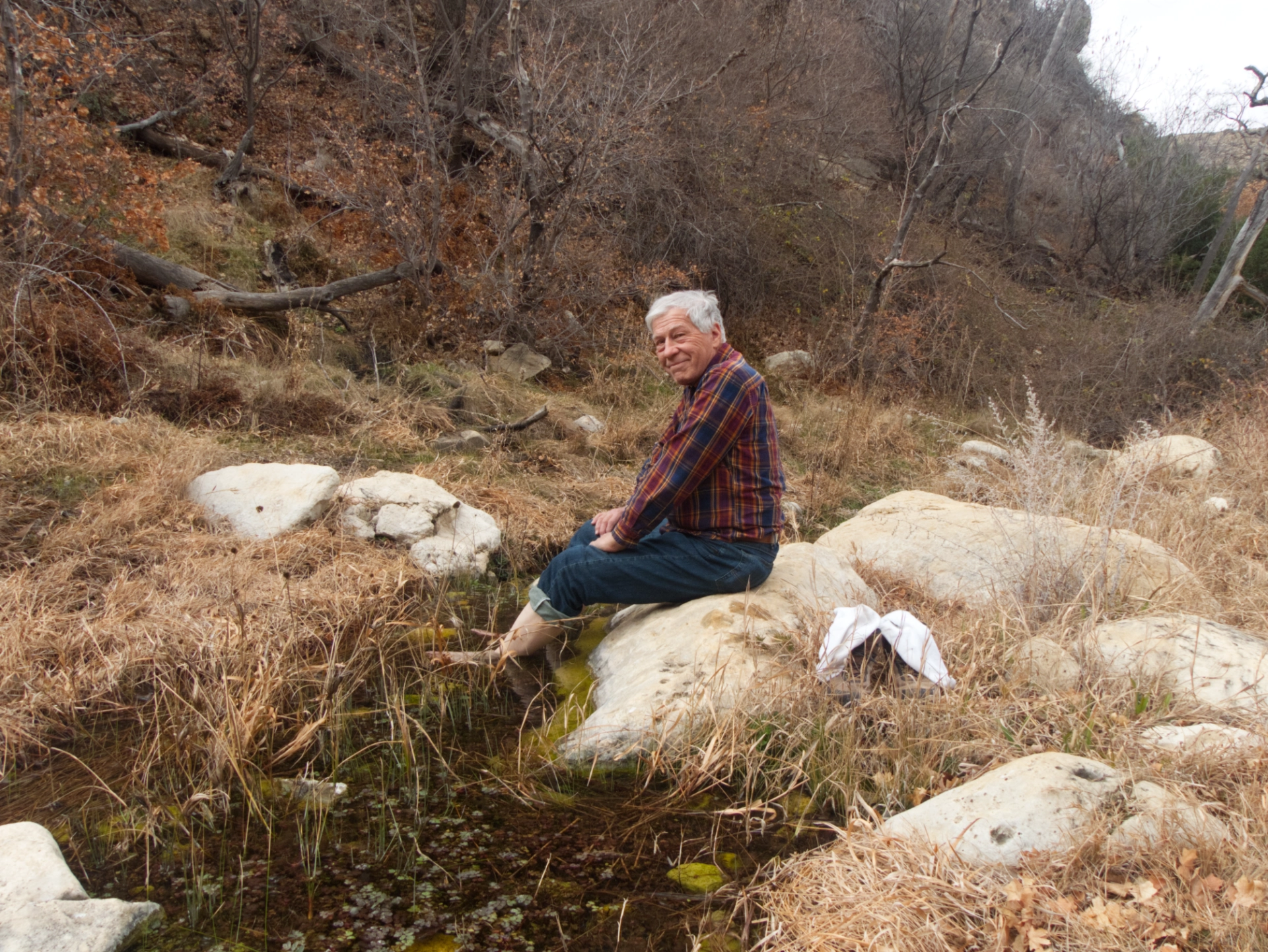Dennis soaking his feet in a pool in Sitting Bull Canyon