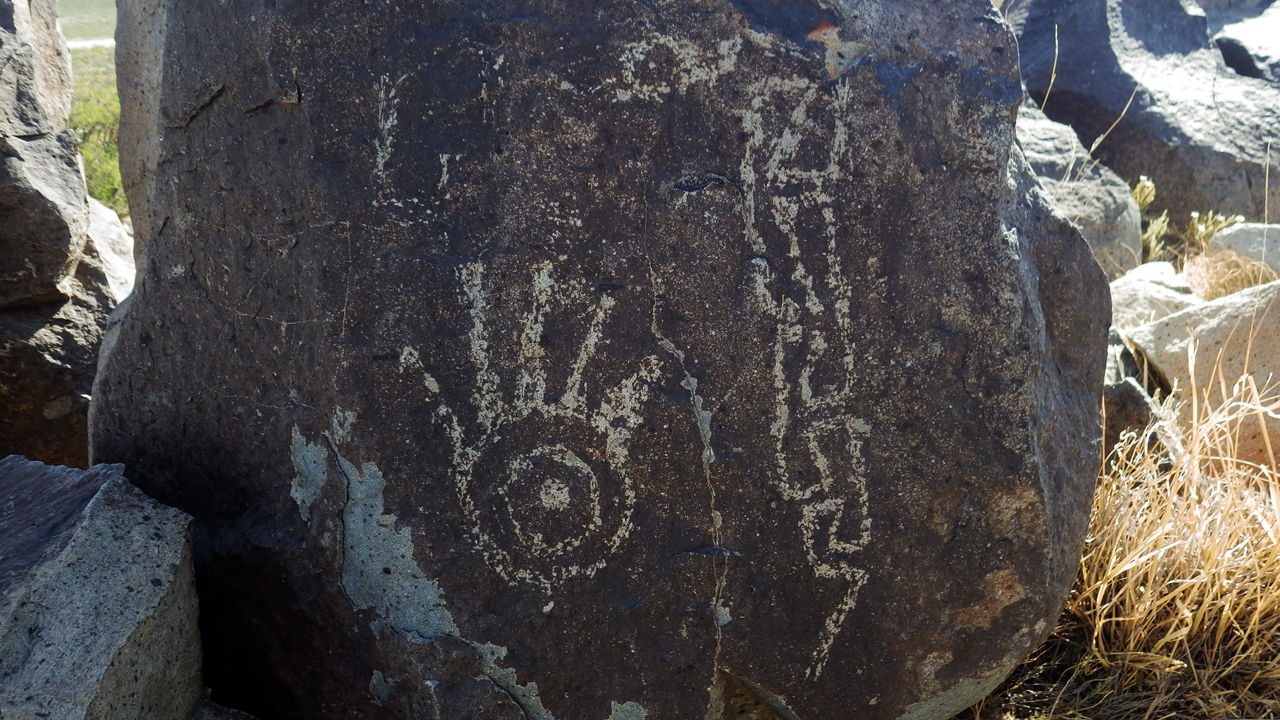 close-up o hand and snake petroglyph